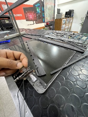 Técnico desarmando pantalla de laptop